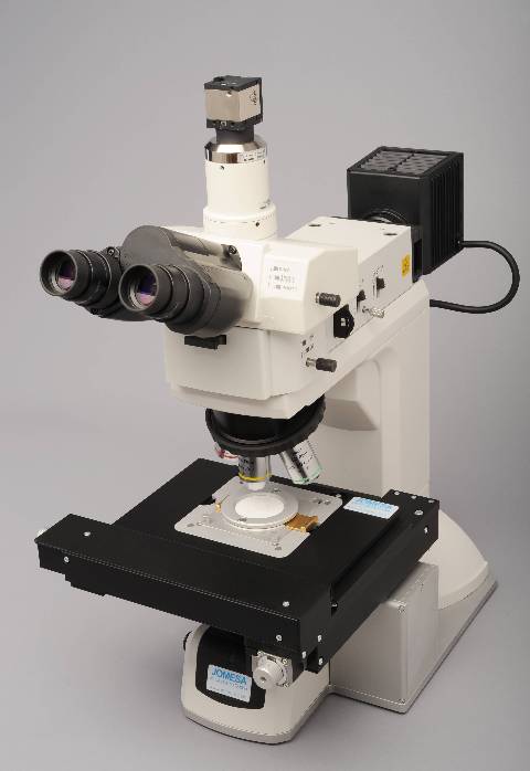 Materialmikroskop in schwarz weiß von Jomesa vor grauem Hintergrund.